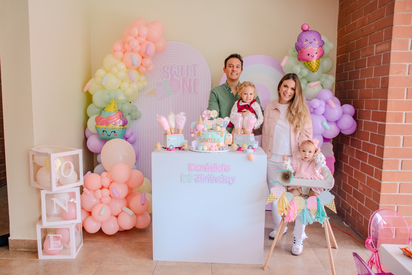 Familia reunida en una fiesta con decoración rosa y globos de estrellas