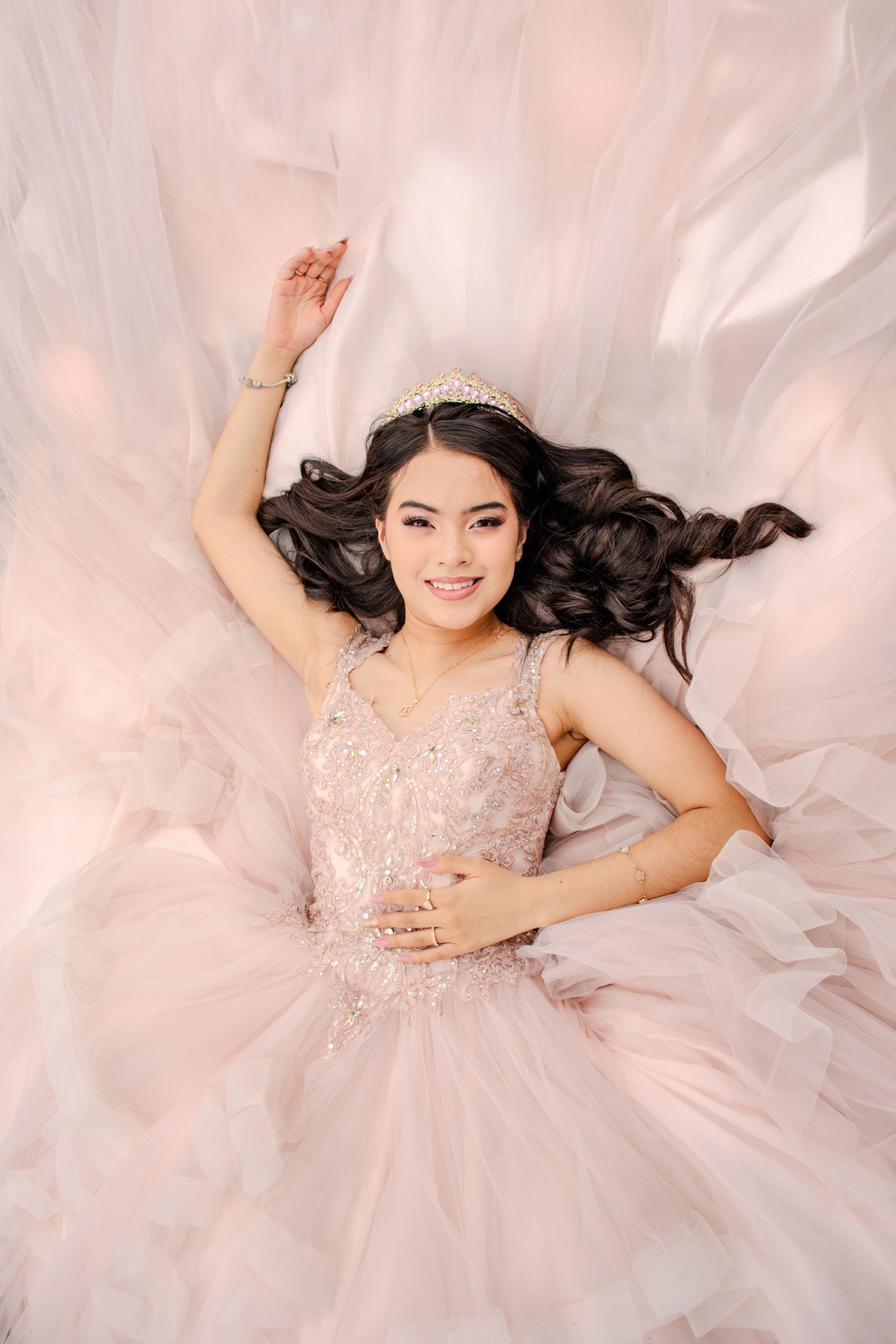 Retrato desde arriba de una joven sobre su vestido rosa